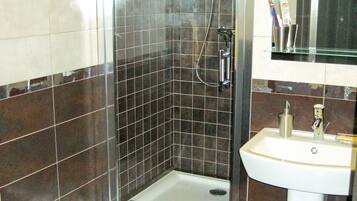 Une salle de bain avec une douche à parois de verre, un lavabo et un miroir au-dessus.