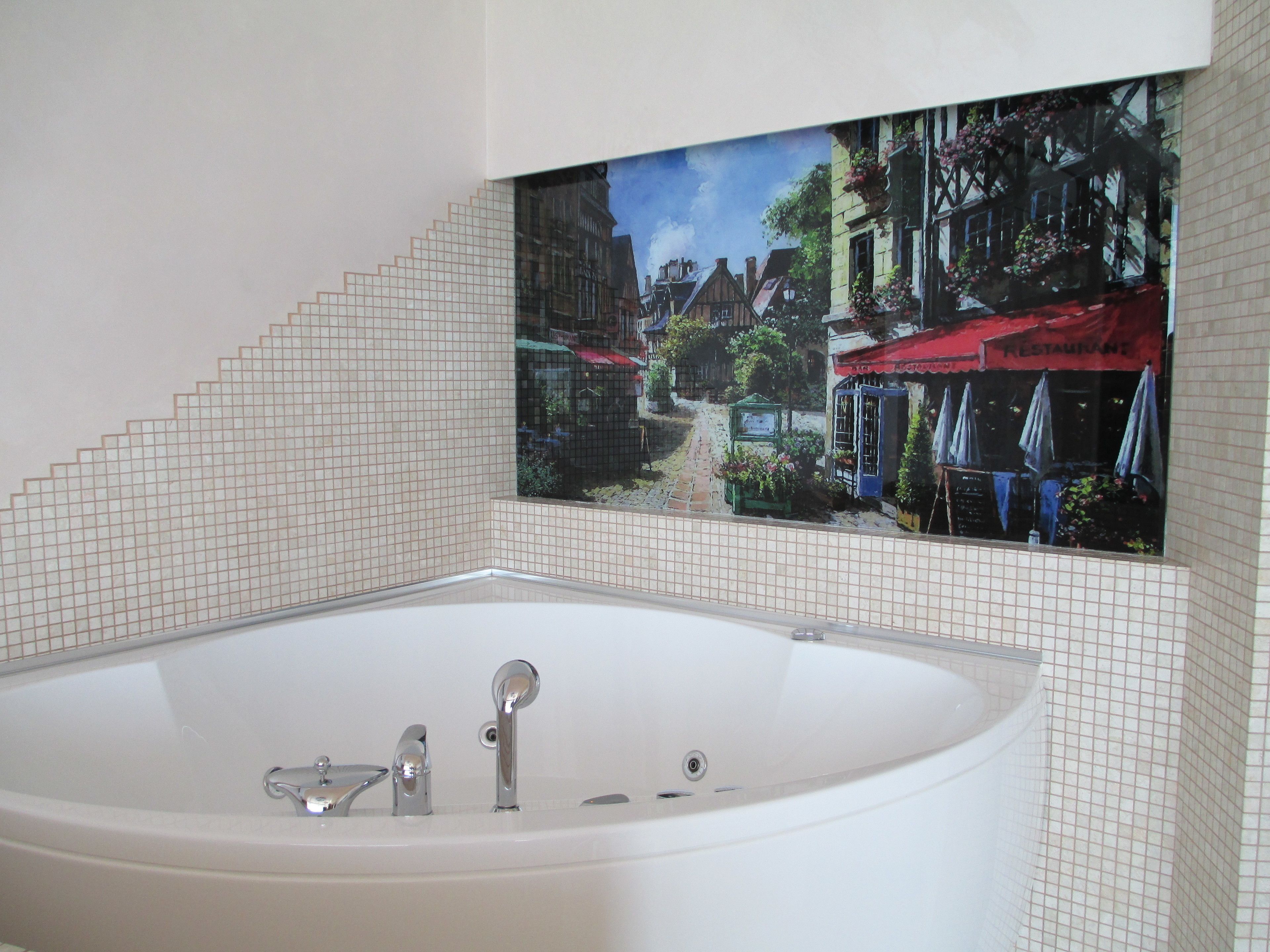 Une salle de bain avec une grande baignoire, des murs carrelés et une fresque représentant une scène de rue.