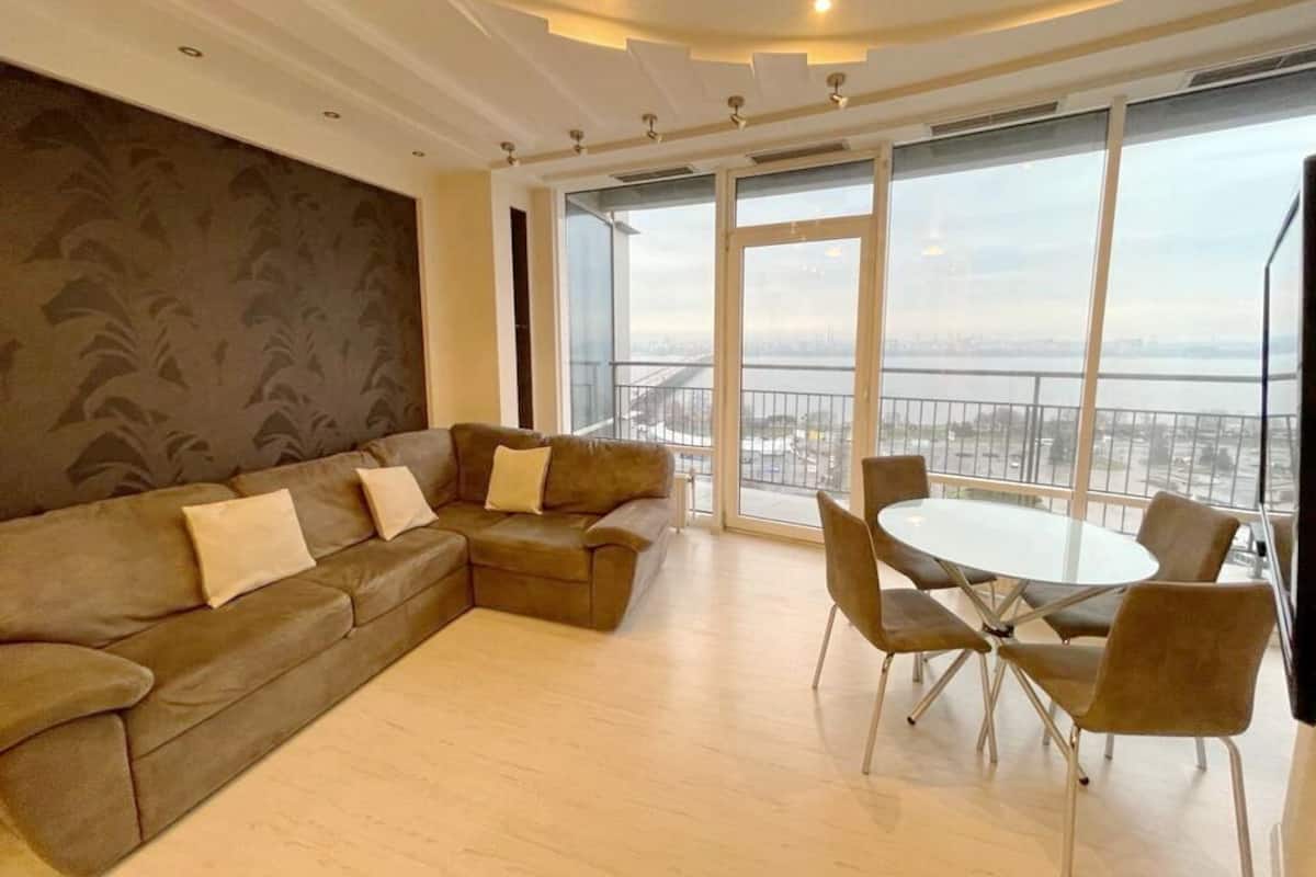 A modern living room with a sofa, a round table, and chairs.