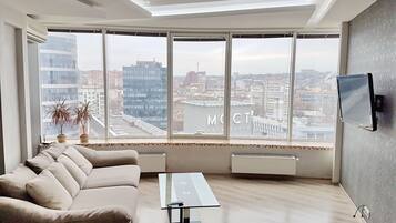 Deluxe Apartment, 1 Bedroom, Kitchen, City View | Living room | Flat-screen TV