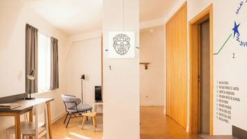 A modern, well-lit room with a desk, chair, and a wall-mounted artwork.