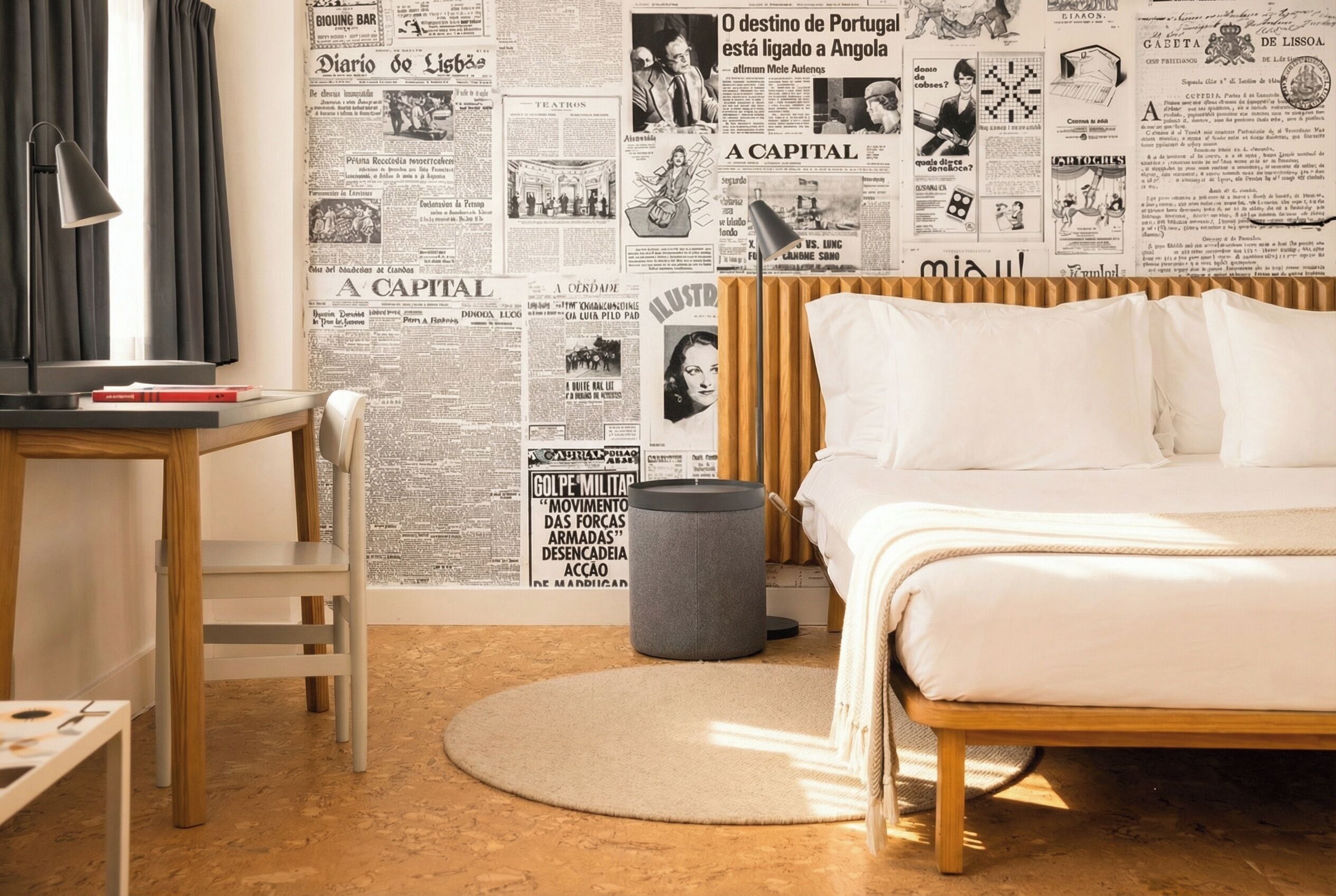 A bedroom with a bed, a desk, a chair, and a round rug.
