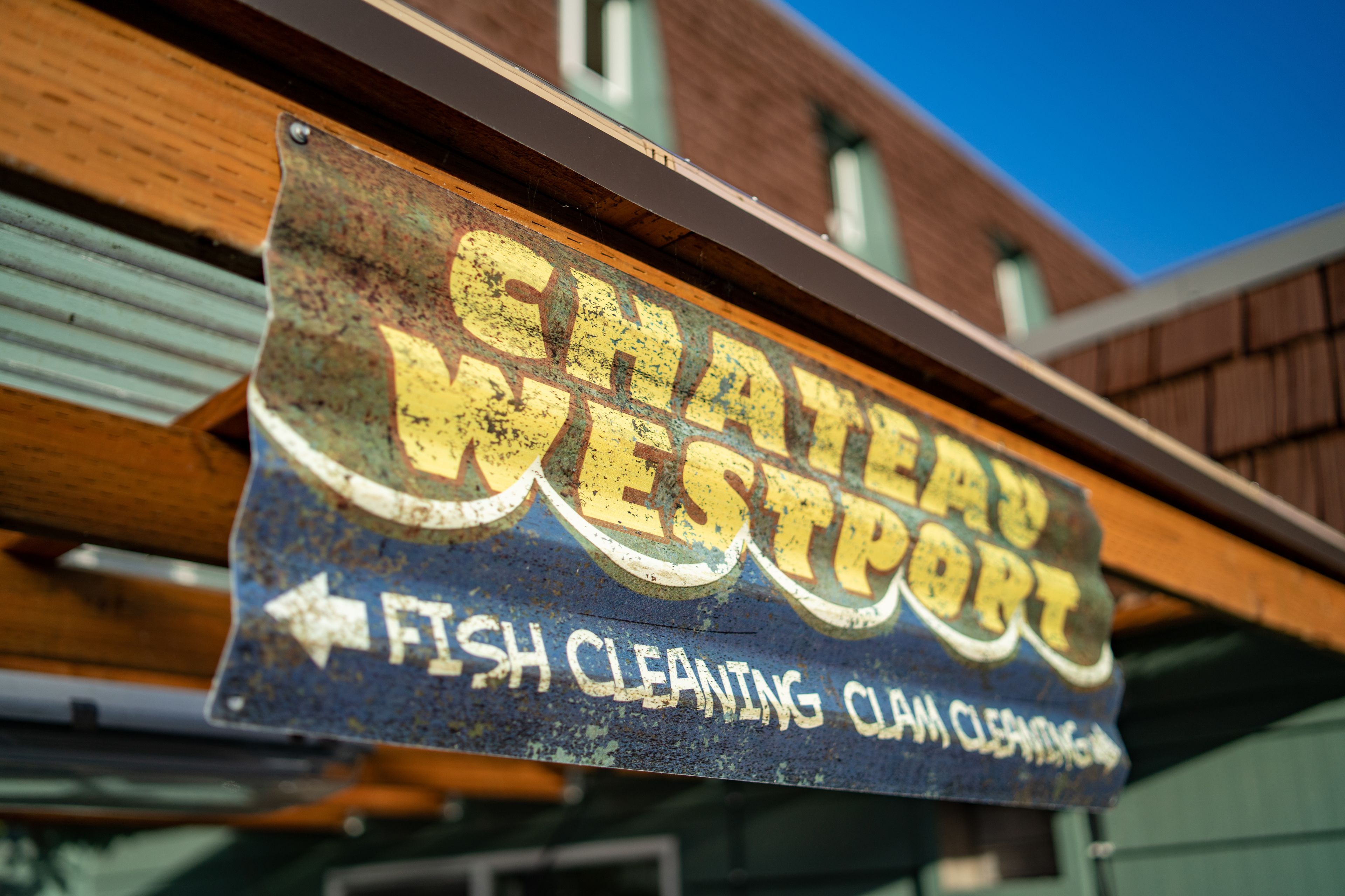 A sign for Chateau Westport indicating fish cleaning and clam cleaning services.