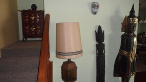 A room with a staircase, a lamp, and a statue. - A Beautiful Edge of the World B&B (Captain Cook)