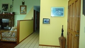 A hallway with a stone fireplace, wooden door, and tiled floor. - A Beautiful Edge of the World B&B (Captain Cook)