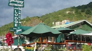 A Gateway Restaurant and Lodge with a green roof and outdoor seating area. - The Gateway Restaurant & Lodge (Three Rivers)
