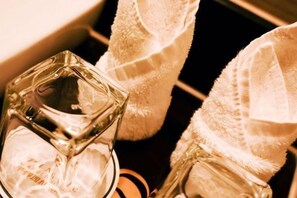 A bottle of perfume with a clear, faceted design, placed on a shelf. - Pingye Garden Hotel (Liangping)