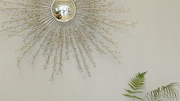 A dark wooden dresser with gold handles and a sunburst mirror above it.