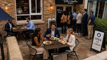 An outdoor dining area with stone walls, wicker chairs, and tables.
