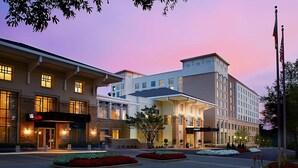 A hotel with a modern facade, large windows, and a landscaped entrance with flower beds. - Hyatt Regency Atlanta Perimeter at Villa Christina (Atlanta)
