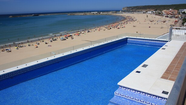 Une piscine avec vue sur une plage et l’océan.