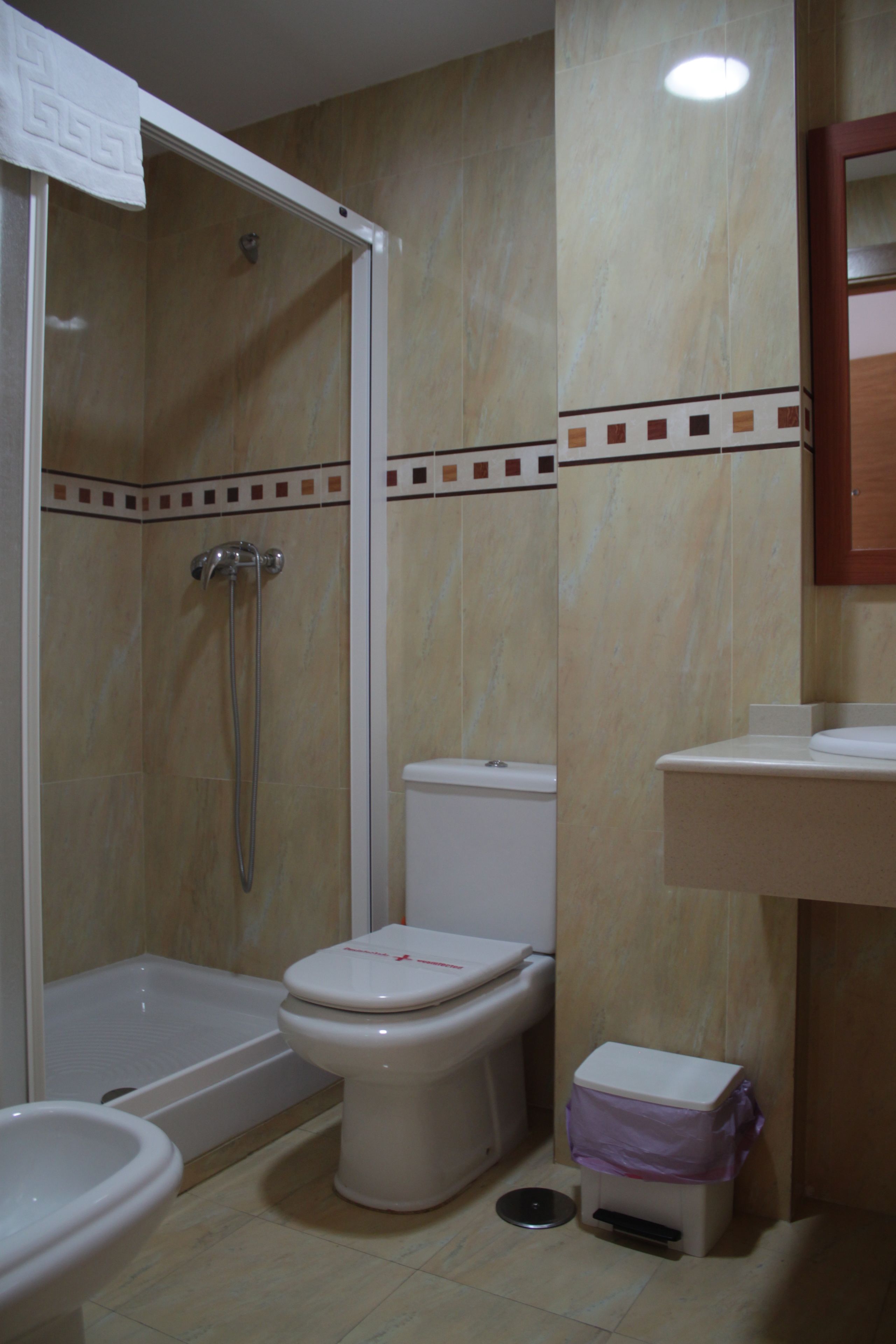Un bagno con doccia, WC, bidet e lavandino.