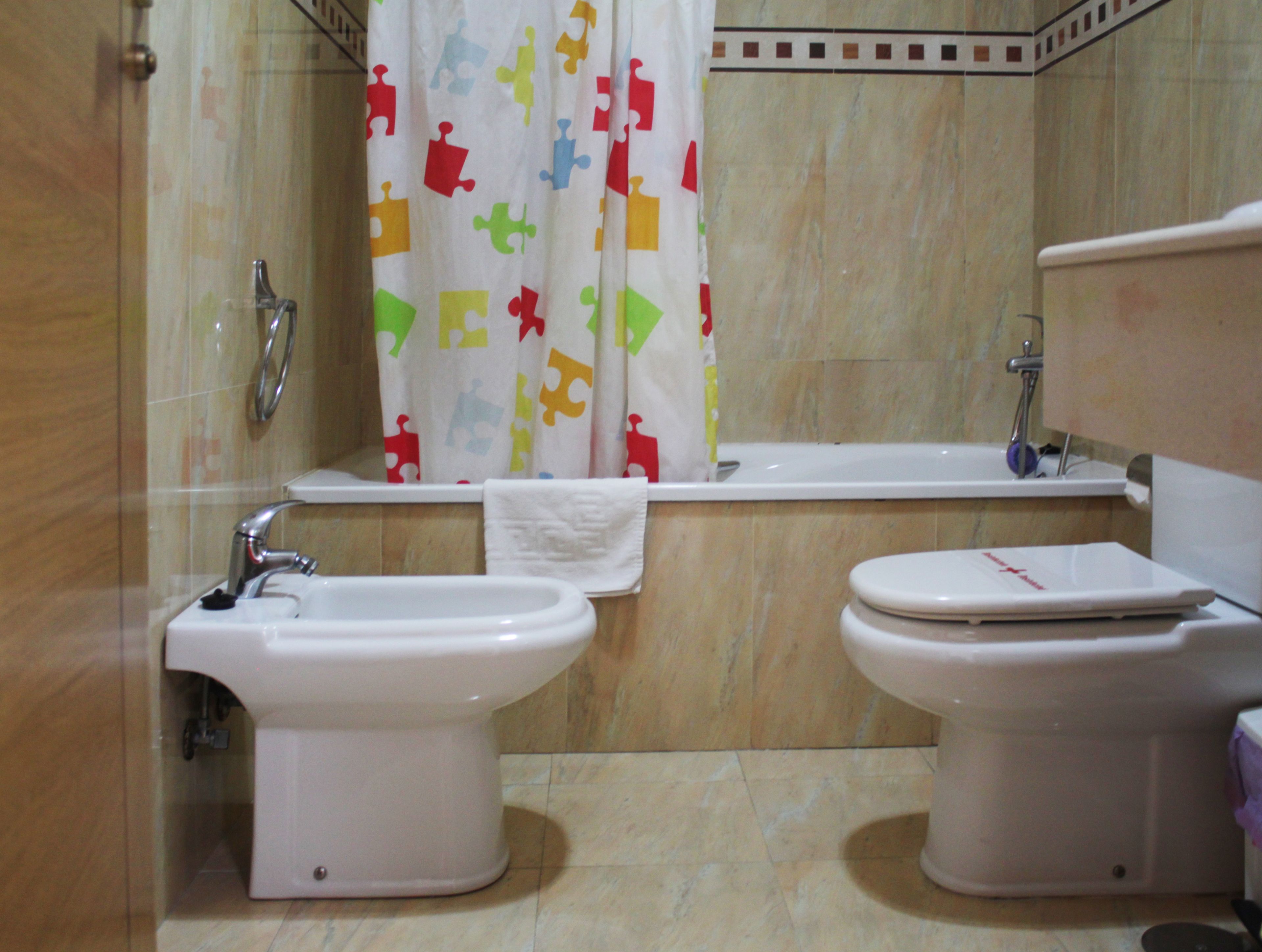 Une salle de bain avec deux toilettes, un bidet et une baignoire.