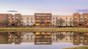 A hotel with a brick facade, a reflection in the water, and a sign reading "Towneplace Suites by Marriott". - TownePlace Suites Jackson Ridgeland/Township at Colony Park (Ridgeland)