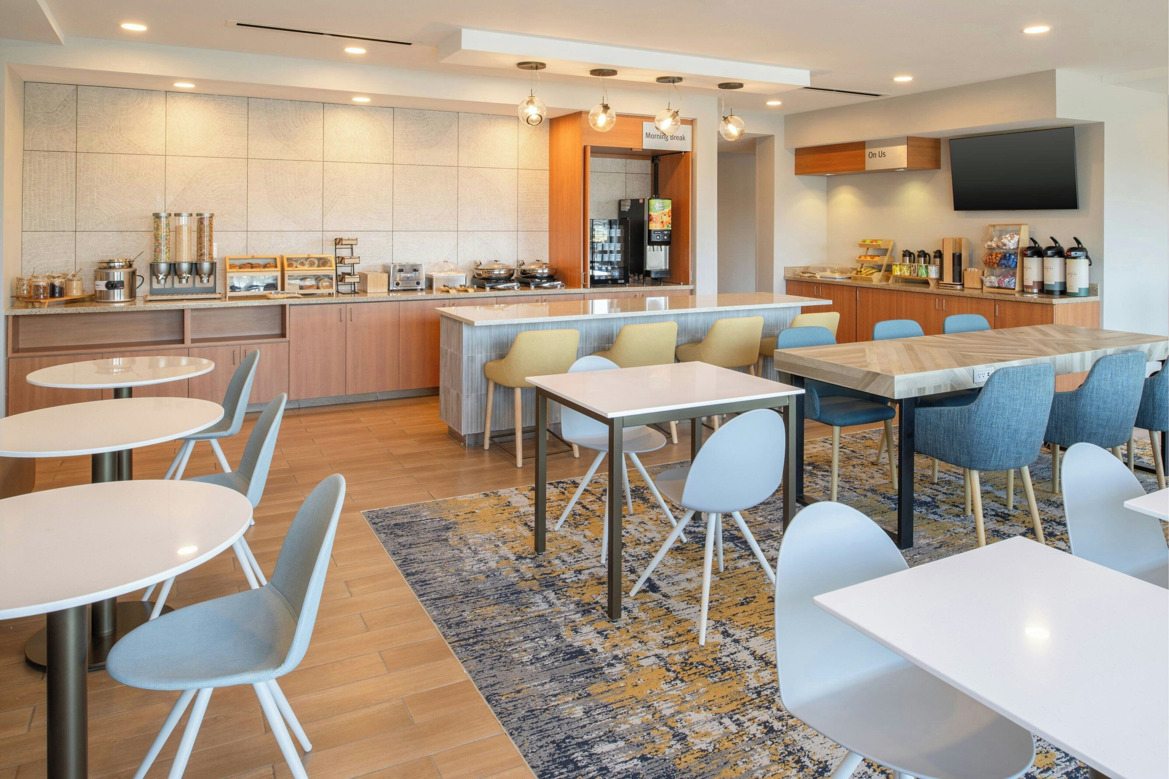 A modern kitchen with a central island, bar area, and seating for 12.