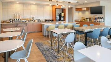 A modern kitchen with a central island, bar area, and seating for 12.