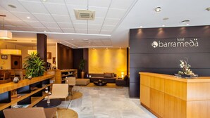 A hotel lobby with a reception desk, seating area, and a bar. - Hotel Barrameda (Sanlucar de Barrameda)