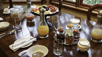 Una mesa de comedor dispuesta con diversos alimentos, bebidas y aderezos.