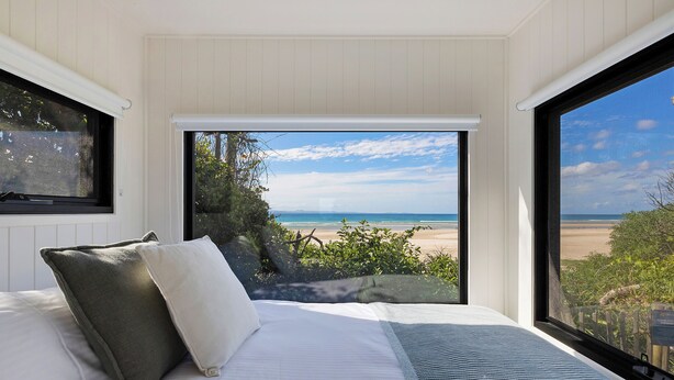 A bedroom with a large window offering a view of the beach. - Reflections Byron Bay - Holiday Park (Byron Bay)