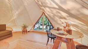 A tent with a dining table, chairs, and a sofa. - Reflections Byron Bay - Holiday Park (Byron Bay)