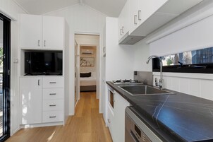 A modern kitchen with white cabinetry, a black countertop, and a built-in oven.