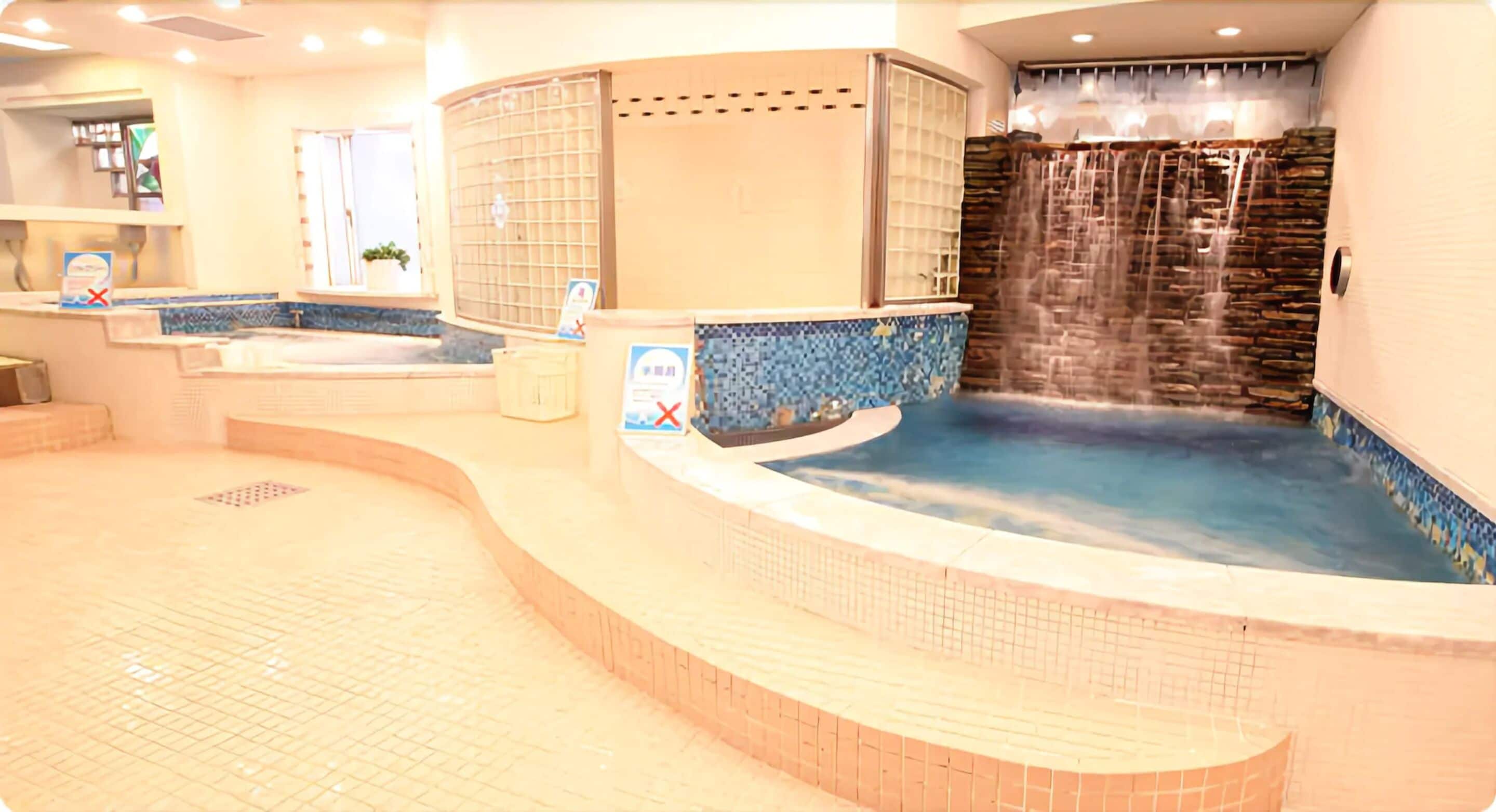 A spa area with a hot tub, a waterfall feature, and a reception desk.