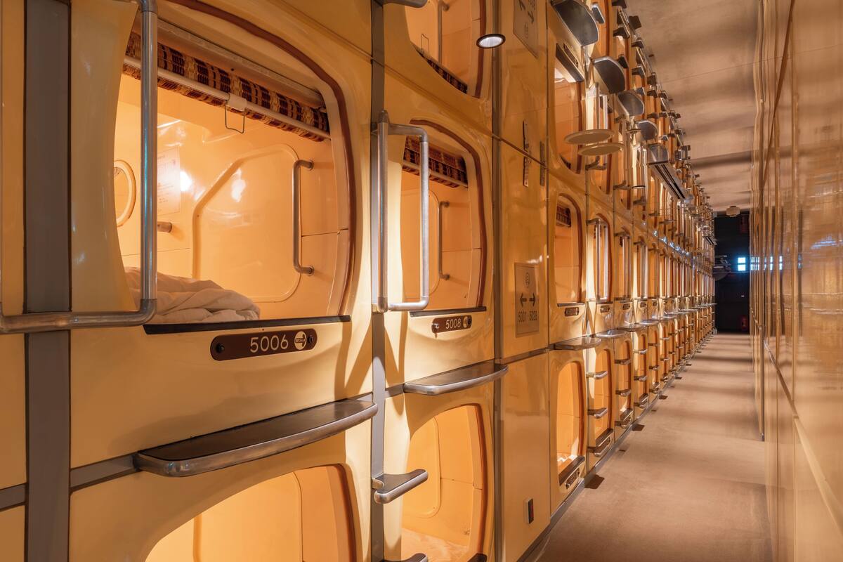 A row of bunk beds with numbers 5006 and 5008, metal railings, and a corridor.