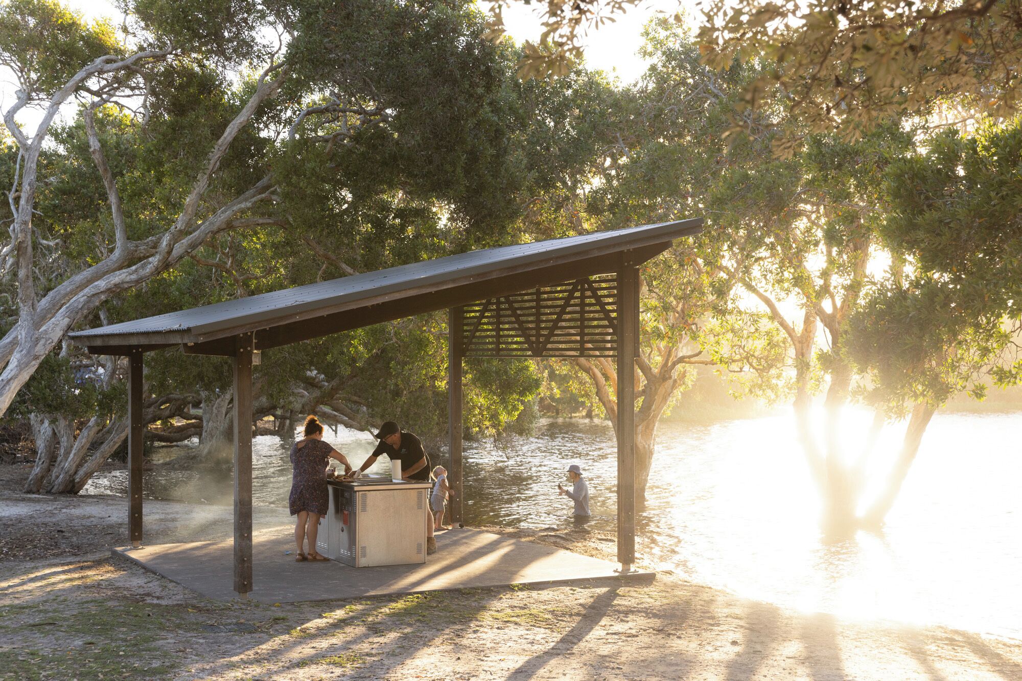 A covered outdoor area with a water feature, surrounded by trees.
