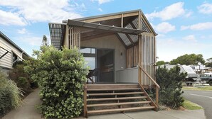 A modern building with a wooden staircase leading to a covered entrance. - Reflections Shaws Bay - Holiday Park (East Ballina)