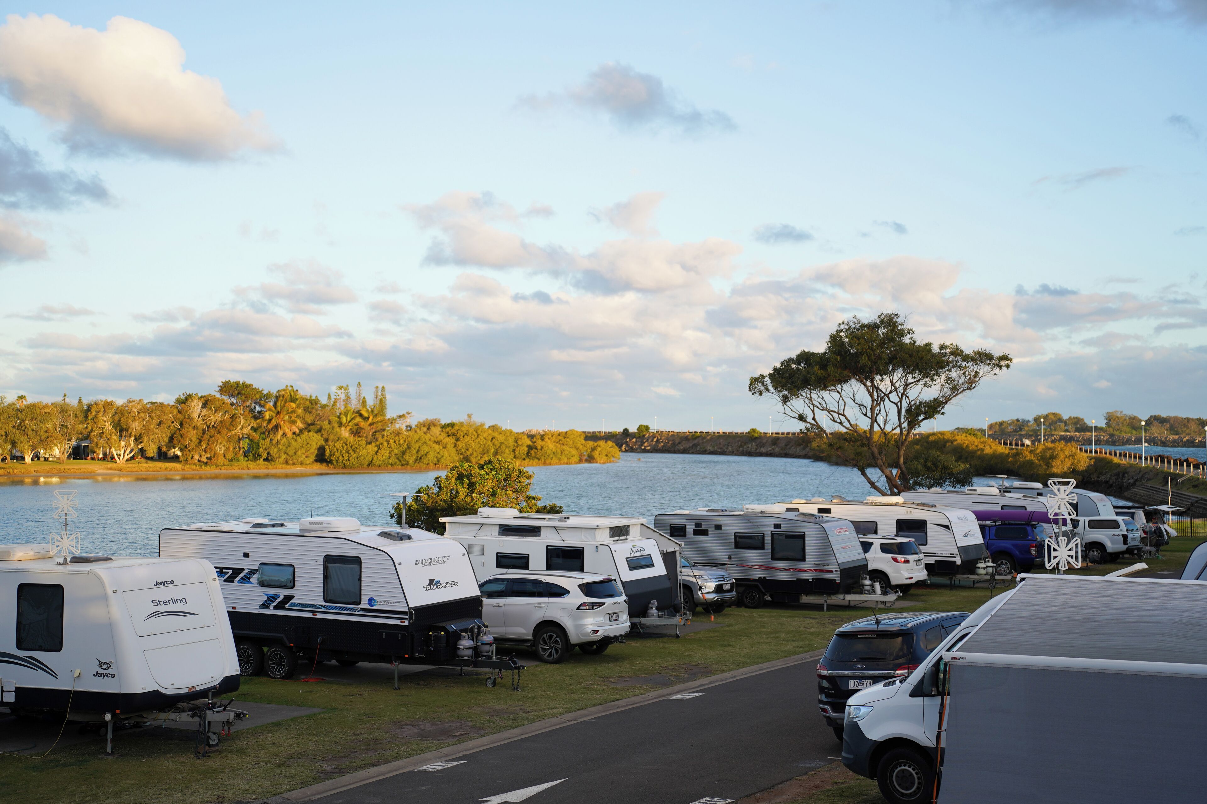 Un camping où de nombreuses caravanes sont stationnées au bord d’un lac.