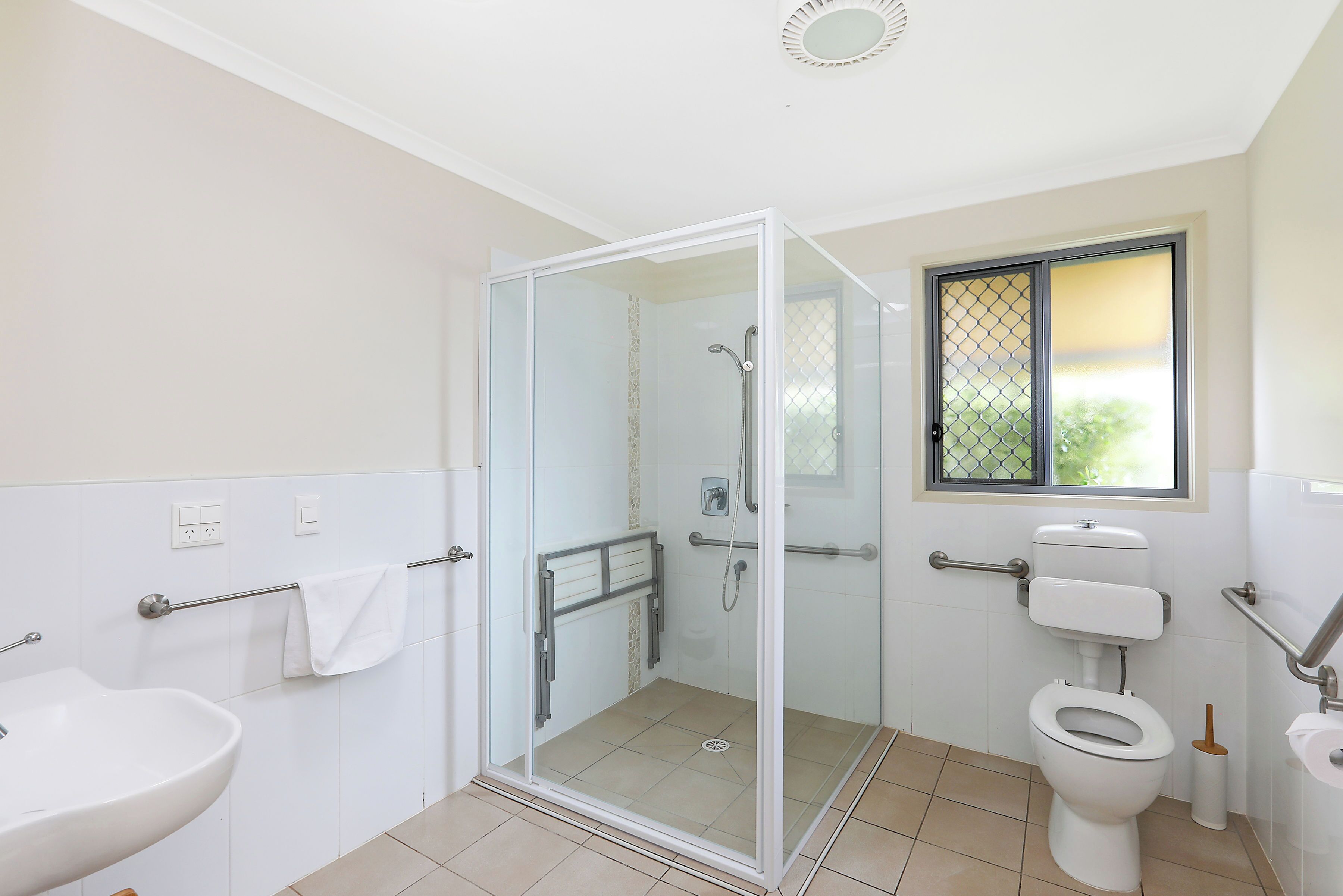Ein Badezimmer mit Duschkabine, Toilette und Waschbecken.