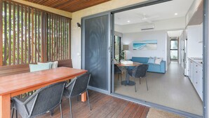 A modern kitchen with white cabinets and a large island. - Reflections Shaws Bay - Holiday Park (East Ballina)