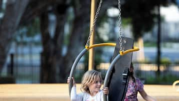 Two children on a swing set at a playground.