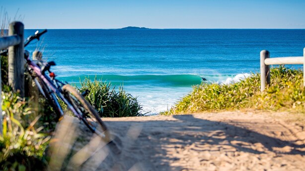 A pathway leading to a beach with a bicycle in the foreground and a view of the ocean. - Reflections Red Rock - Holiday Park (Red Rock)
