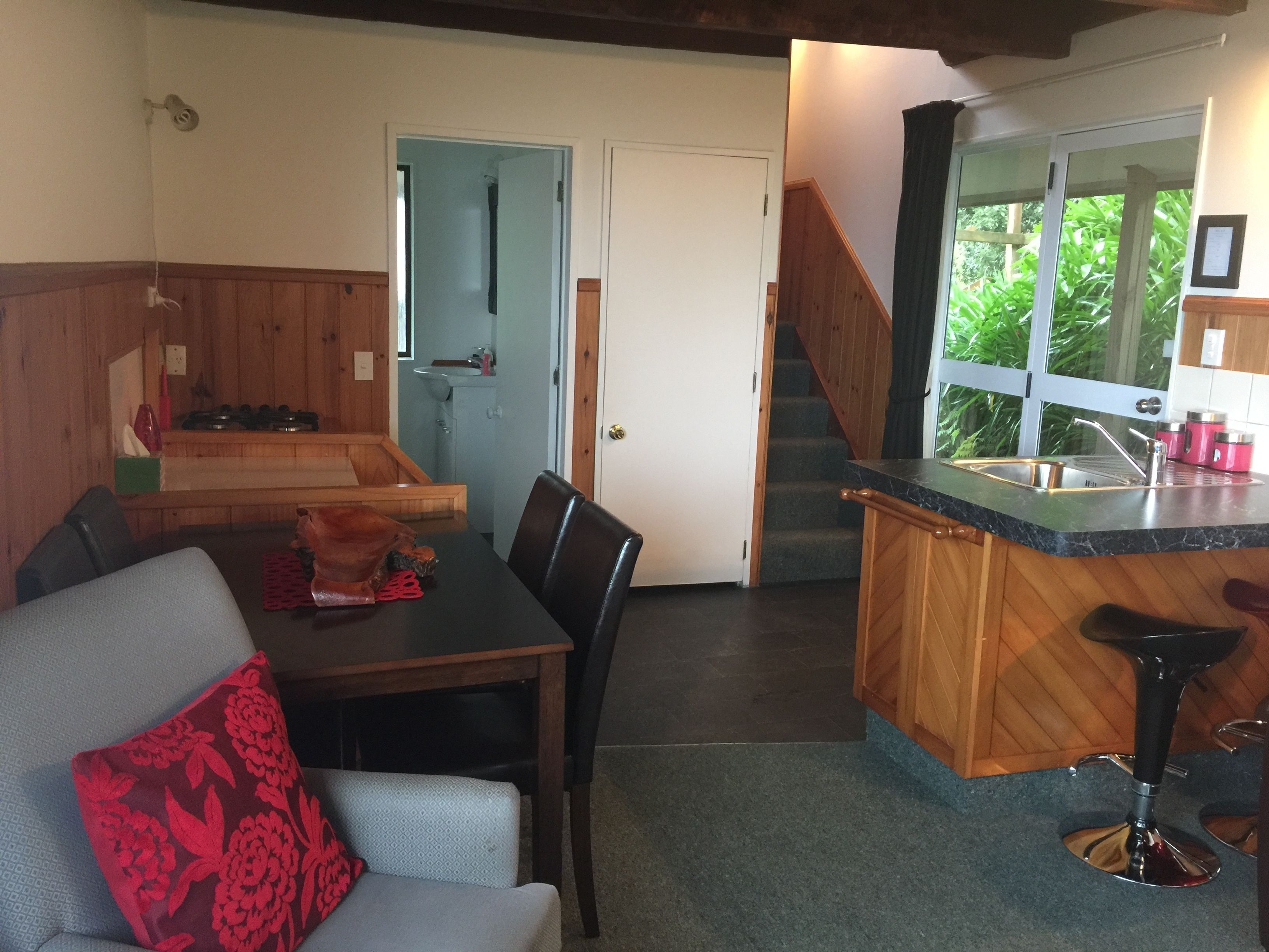 Una cocina acogedora con encimera de madera, un fregadero y una escalera que sube a otro nivel.