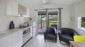 Una cocina moderna con comedor, ventilador de techo y vistas al exterior.