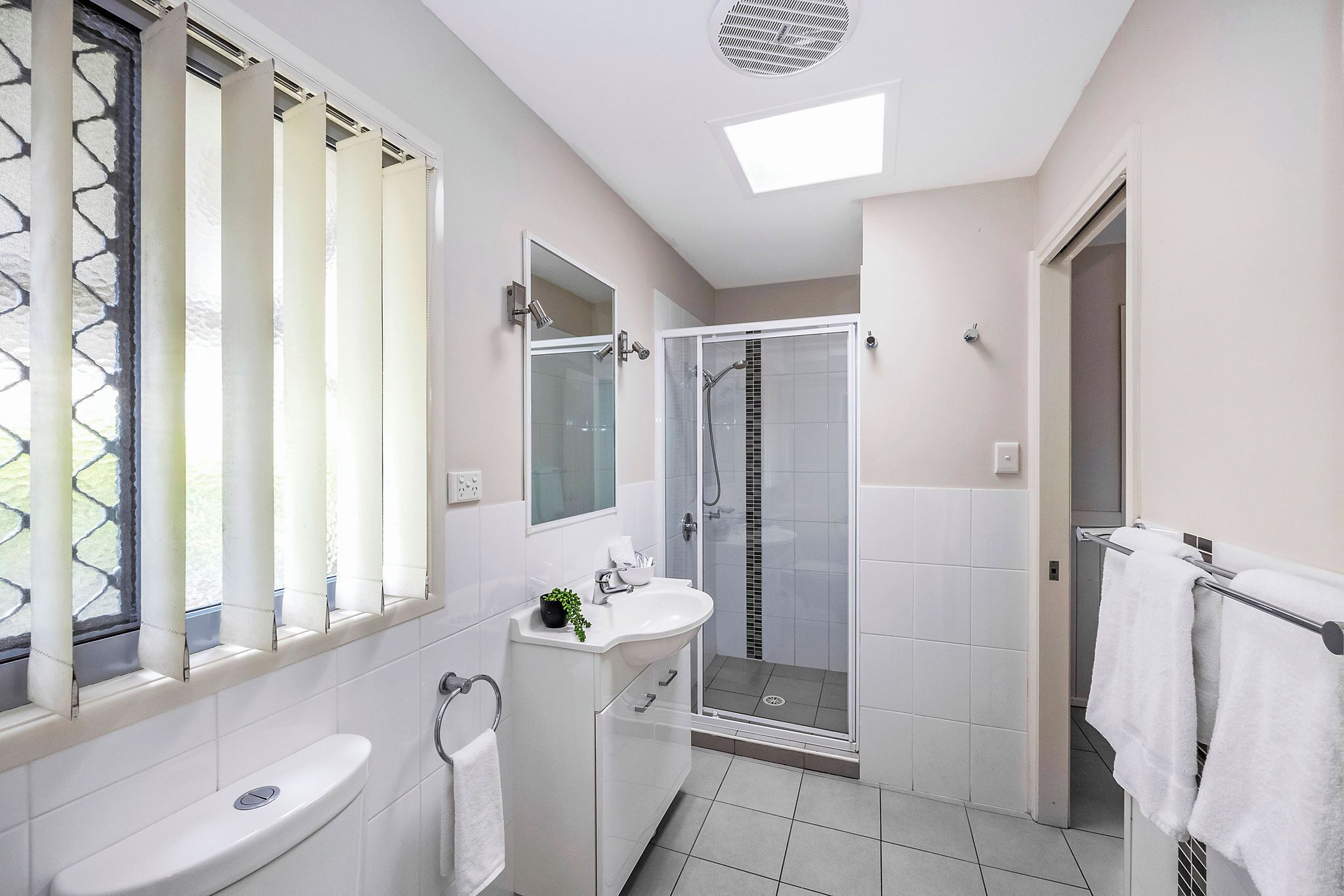 A modern bathroom with a toilet, sink, and shower area.