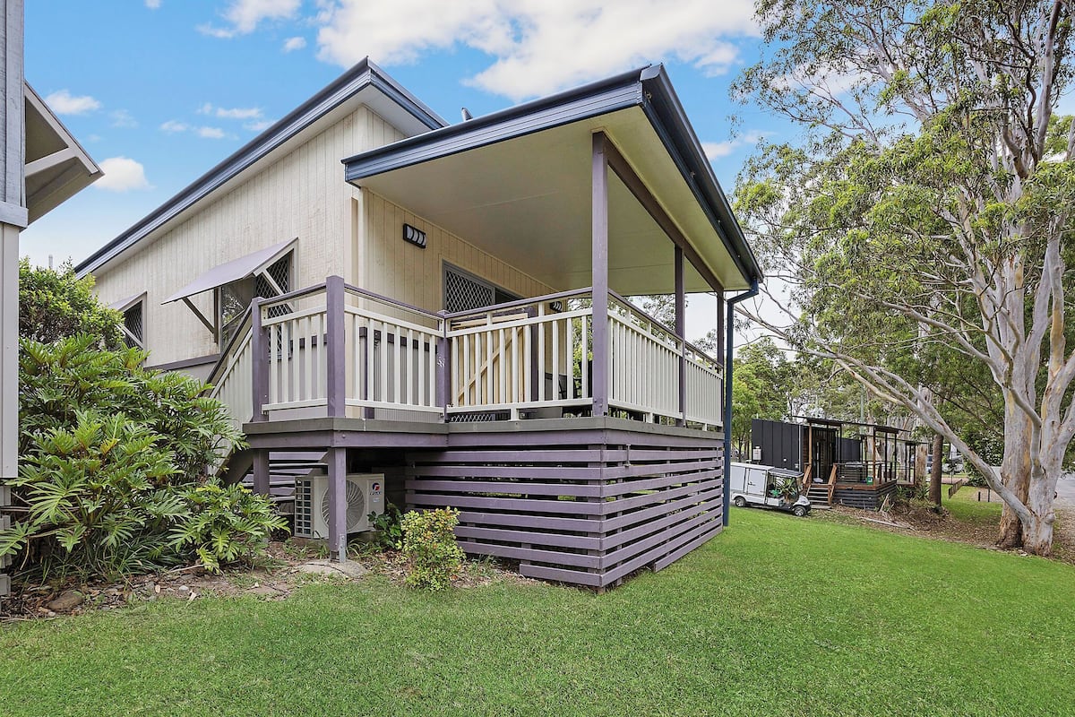 A two-story house with a covered porch and a small deck.