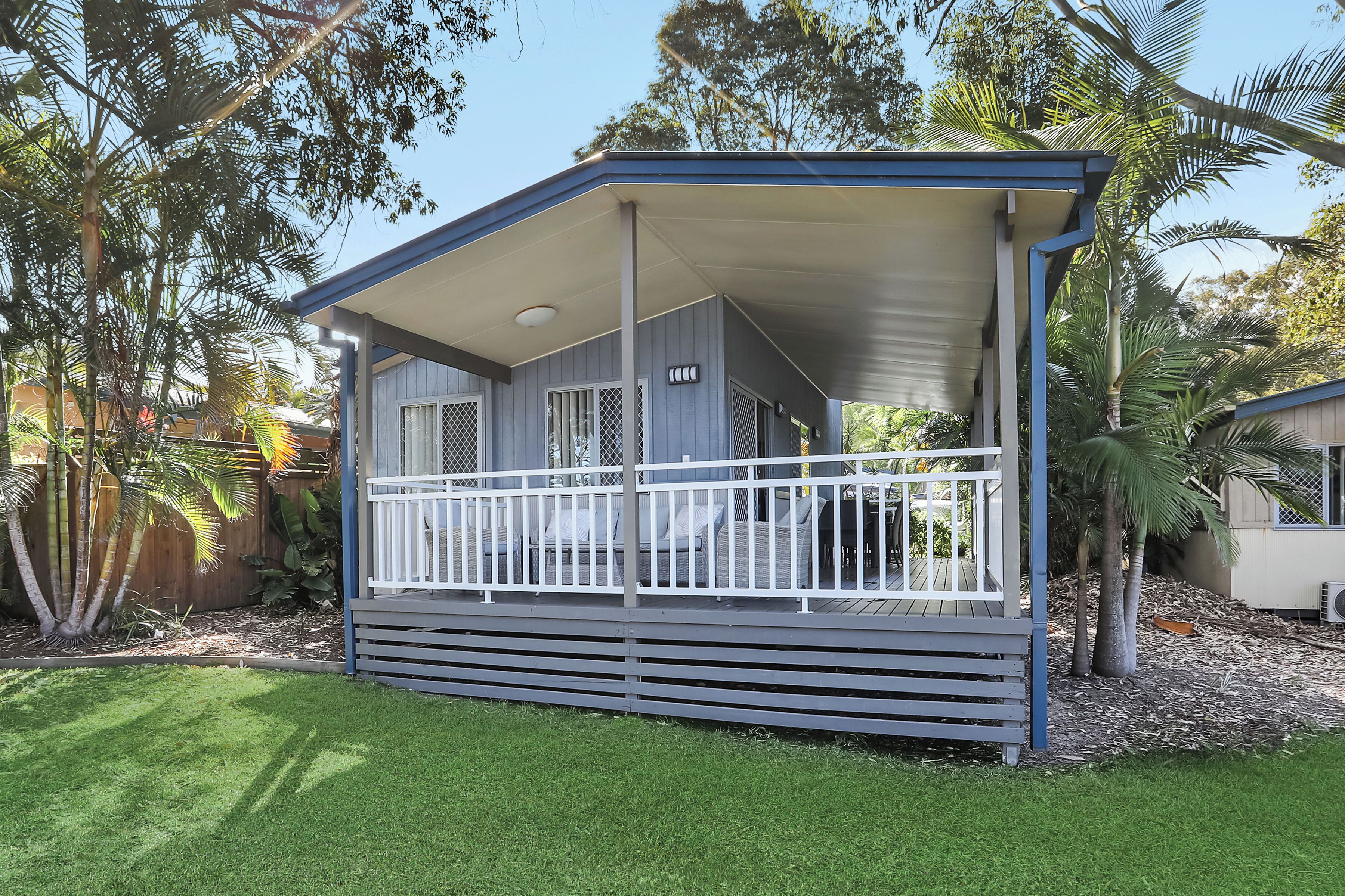 A single-story house with a covered porch and a fenced deck.