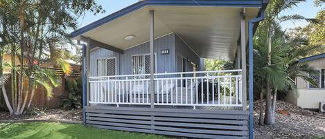 A single-story house with a covered porch and a fenced deck.