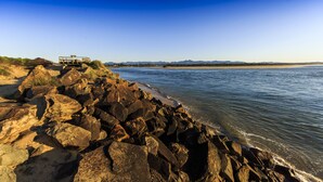 A rocky shoreline with a wooden structure overlooking the water.