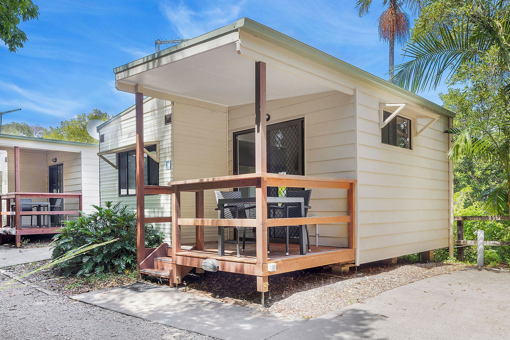 Une maison mobile de plain-pied dotée d’un porche couvert et d’une petite terrasse.