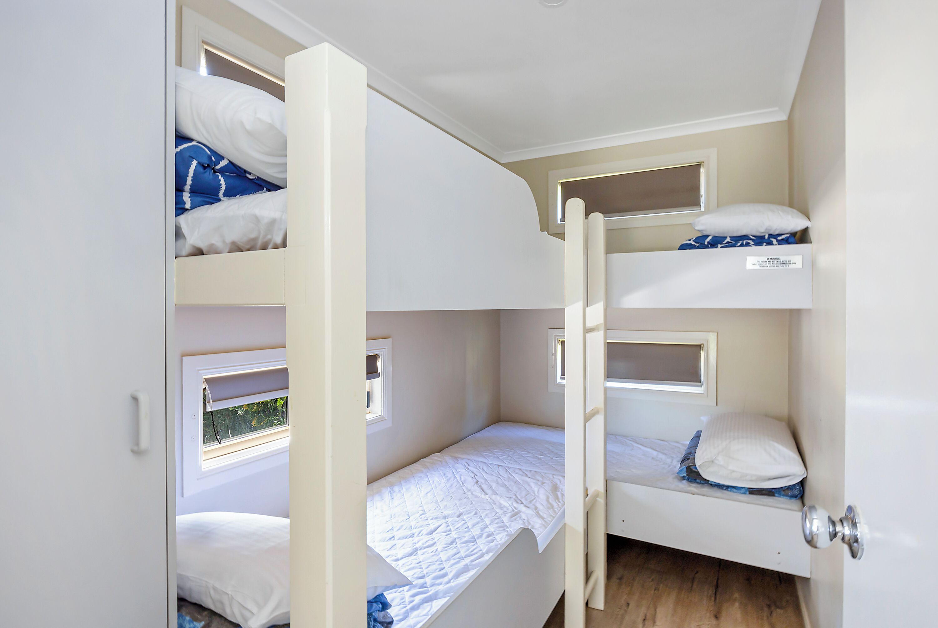 A compact room with bunk beds, a window, and a door.