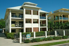 Un hôtel à plusieurs étages, doté de balcons, d’une piscine et d’un panneau indiquant qu’il propose des locations de vacances.