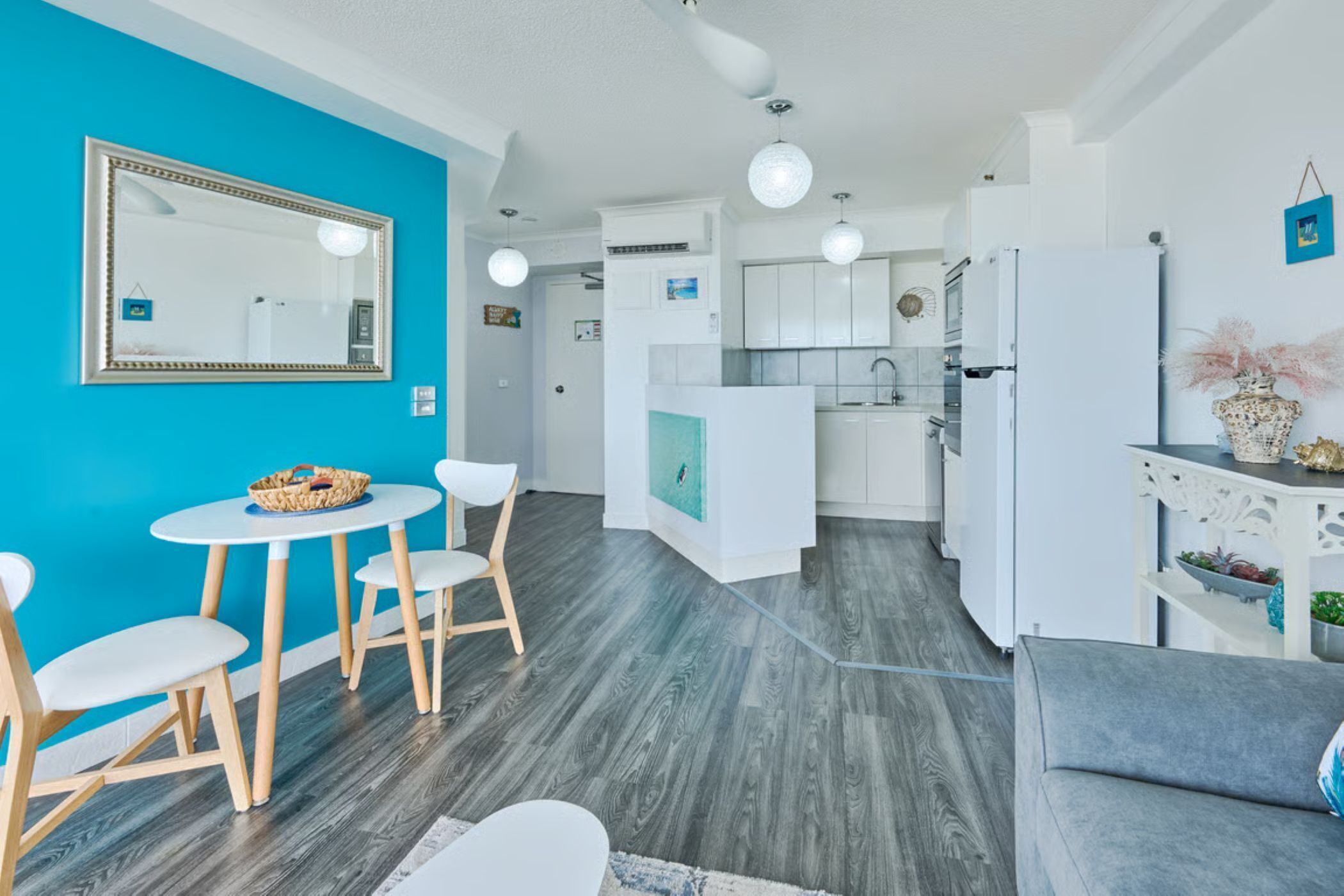 Eine moderne Küche mit weißen Schränken, einem eingebauten Backofen und einem Kühlschrank.