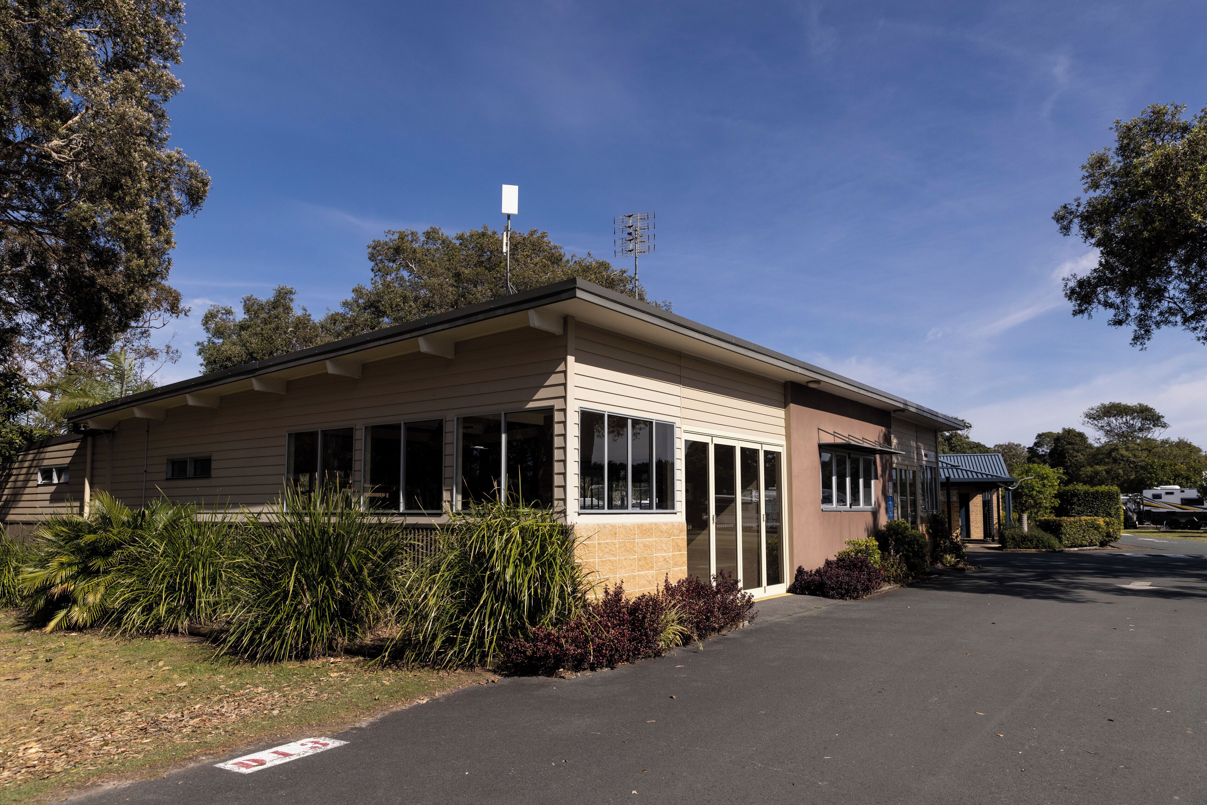 A single-story building with a flat roof, large windows, and a covered entrance.