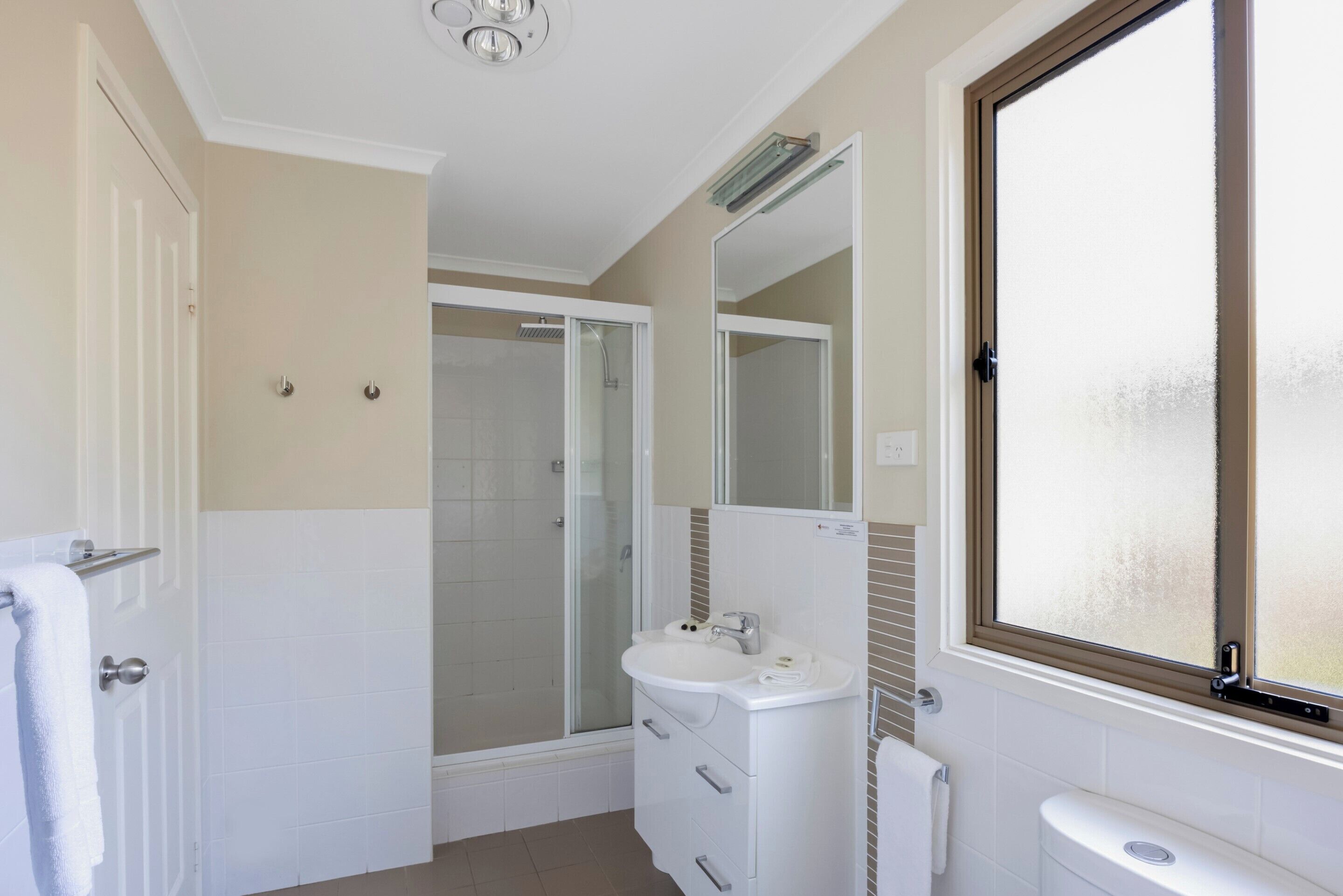 A bathroom with a shower, sink, and toilet.