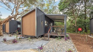 Una cabaña moderna y compacta con fachada de madera y un pequeño porche.