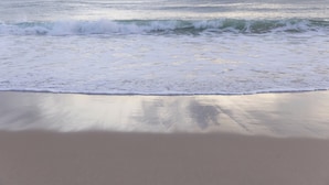 A beach with waves approaching the shore.