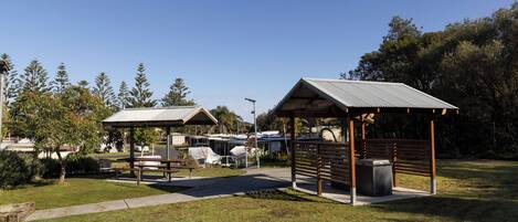 A park with two gazebos, picnic tables, and a paved walkway.